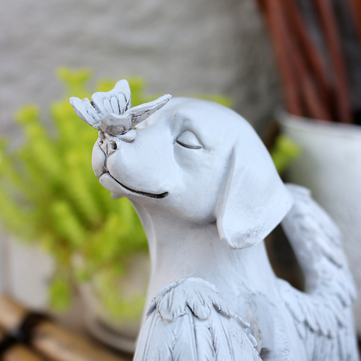 Close-up of dog memorial statue with butterfly resting on its nose