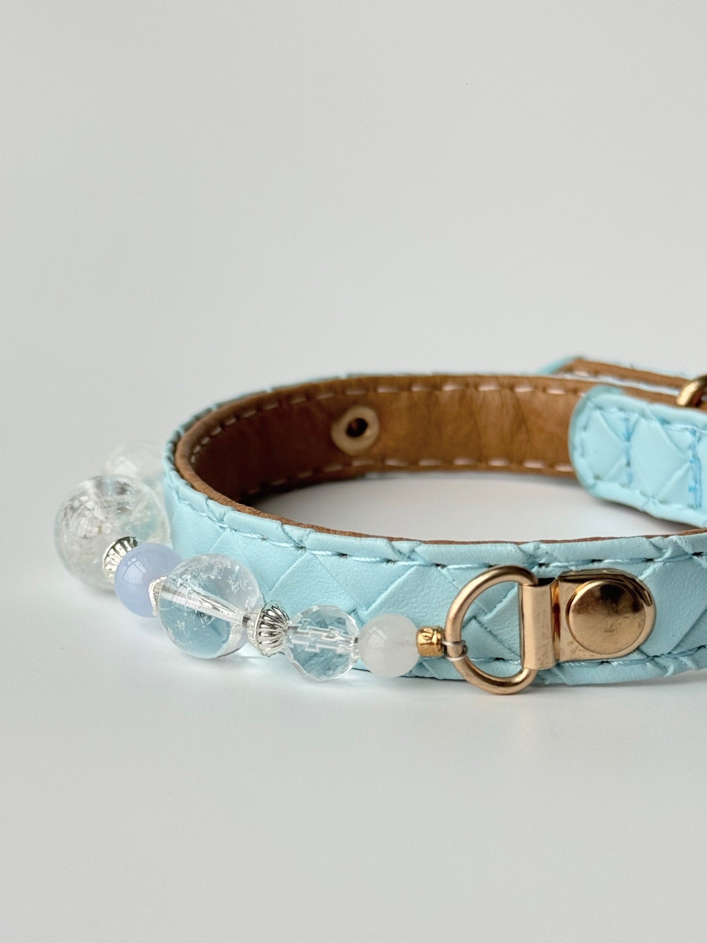 Gold-tone buckle and gemstone detail on pale blue pet collar