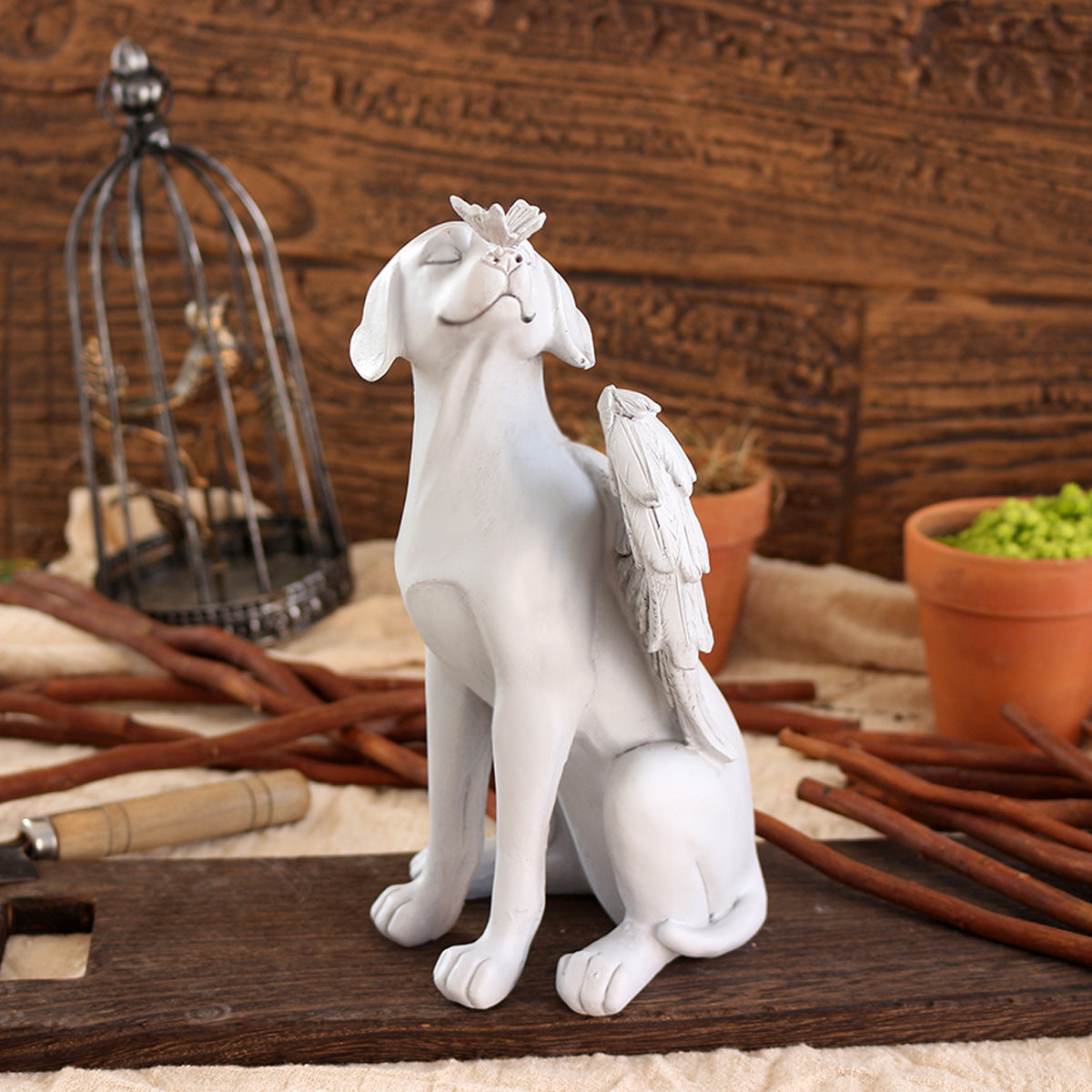 Angel dog memorial sculpture displayed on a wooden surface